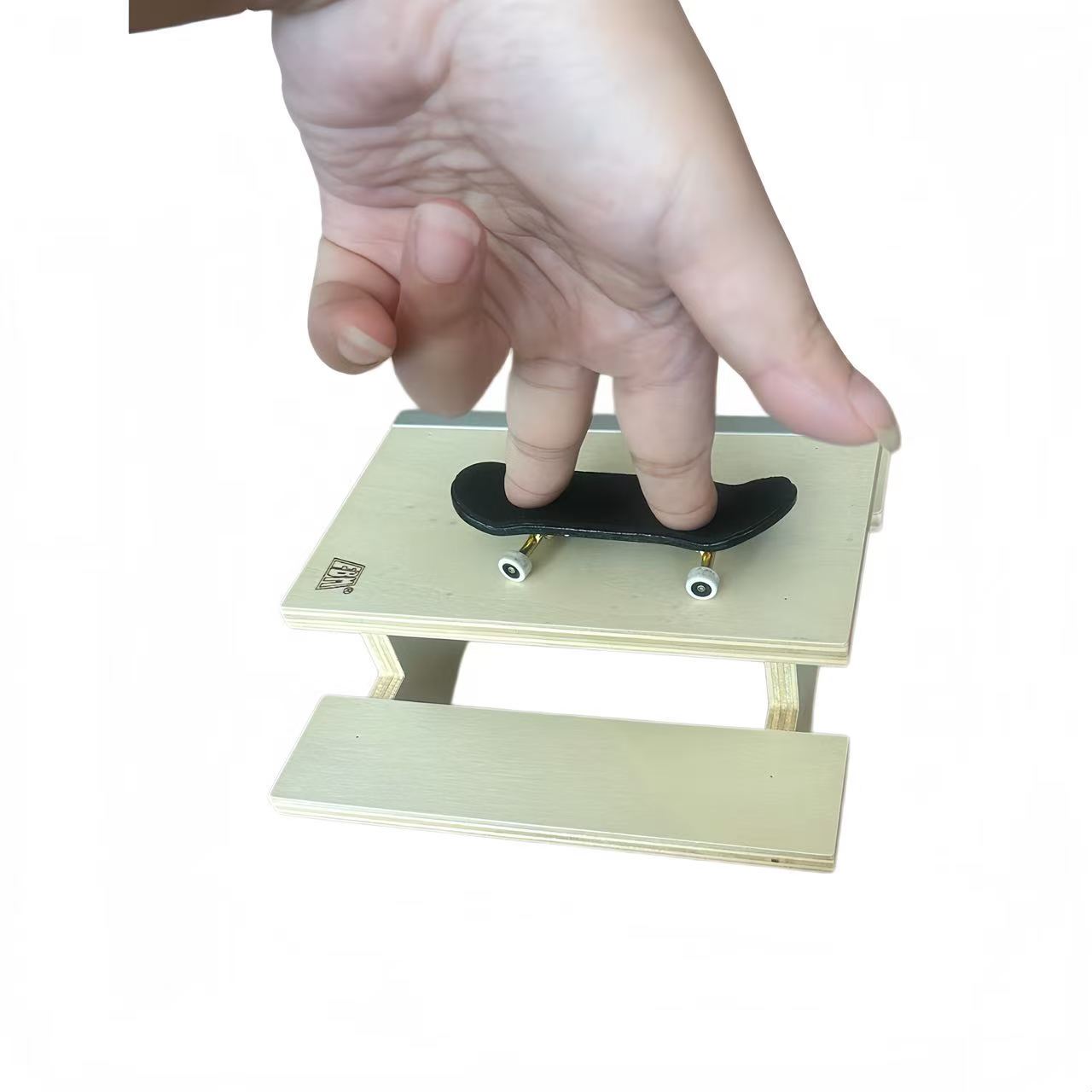 Desktop fingerboard skate park setup with wooden obstacle
